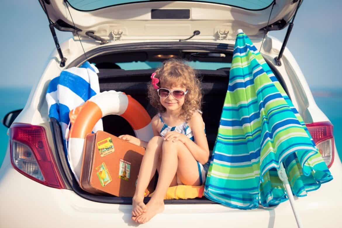 Little Girl Sitting In Car With Beach Supplies